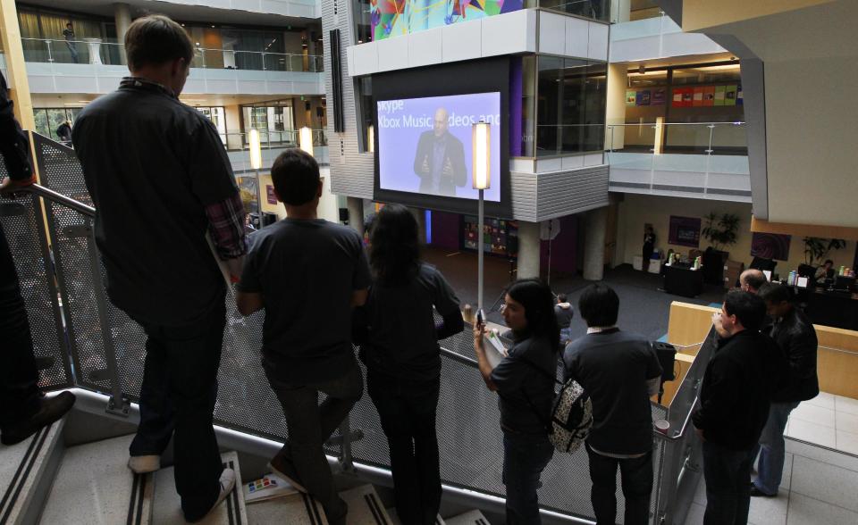 Employees look on as Microsoft CEO Steve Ballmer speaks via a webcast during an event unveiling a new Microsoft Windows operating system Thursday, Oct. 25, 2012, at the company's headquarters in Redmond, Wash. Though Windows 8 will be backed by a $1 billion marketing campaign, questions surround the software. The biggest one of all: Is it innovative and elegant enough to lure consumers who've fallen in love with an assortment of smartphones, tablet computers and other gadgets? (AP Photo/Elaine Thompson)