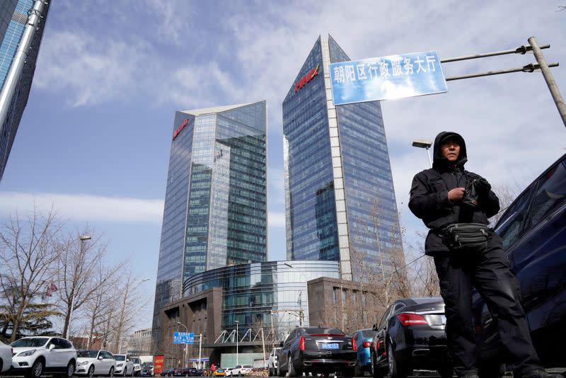 FILE PHOTO: A man walks near the building of HNA Plaza in Beijing