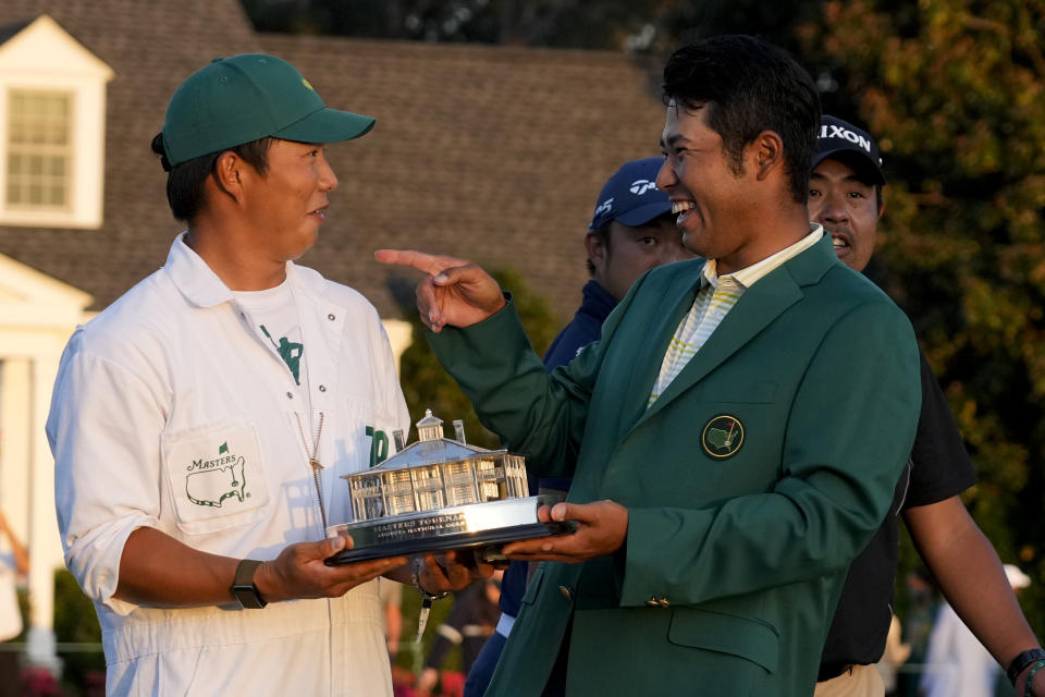 Hideki Matsuyama, of Japan, holds his trophy with his caddie Shota Hayafuji after winning the Masters golf tournament on Sunday, April 11, 2021, in Augusta, Ga. (AP Photo/David J. Phillip)