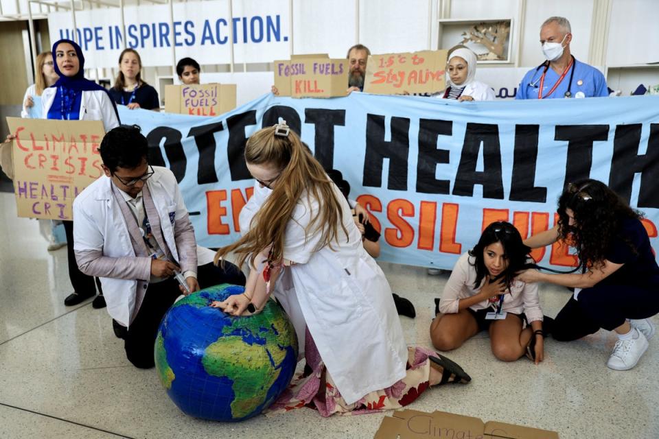 Members of the International Federation of Medical Students Associations hold protest demanding an end to fossil fuels at Cop28 climate summit, in Dubai (REUTERS)