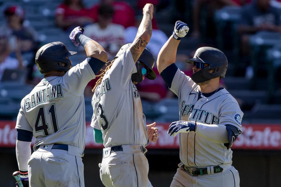 Seattle Mariners' Carlos Santana, left, and J.P. Crawford, center, congratulate Ty France, right, for hitting a three-run home run against the Los Angeles Angels during the seventh inning of a baseball game in Anaheim, Calif., Monday, Sept. 19, 2022. (AP Photo/Alex Gallardo)