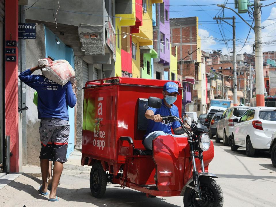 An employee of the Favela Brasil Xpress transport company drives a vehicle carrying packages that will be delivered to residents of the Paraisopolis favela, in Sao Paulo, Brazil, on December 1, 2021.