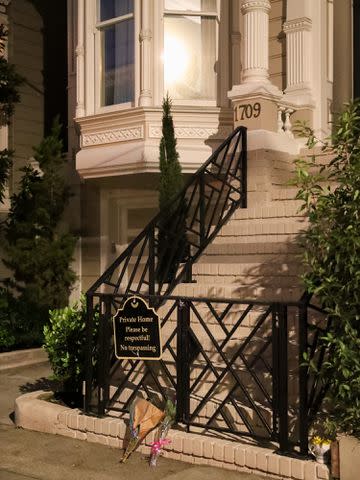 <p>Miikka Skaffari/Getty</p> Flowers left by fans are seen on the steps of "Full House" location in San Francisco.