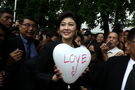 Ousted former Thai prime minister Yingluck holds a balloon as she arrives at the Supreme Court in Bangkok, Thailand, July 21, 2017. REUTERS/Athit Perawongmetha