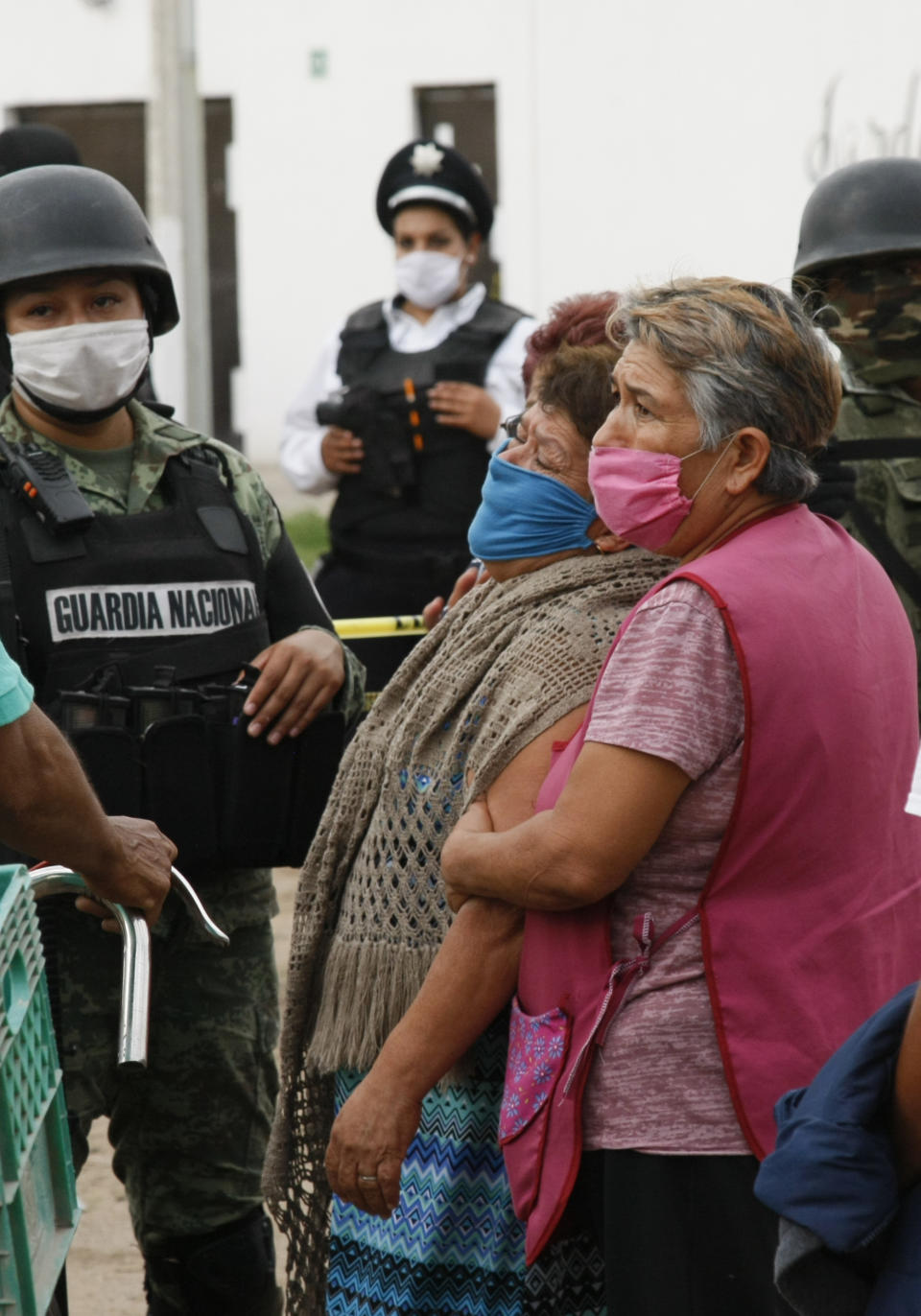 Relatives of the victims of a shooting at an unregistered drug rehabilitation center wait in anguish outside the rehab center in Irapuato, Mexico, Wednesday, July 1, 2020. Gunmen burst into the center and opened fire, killing more than 20 and wounding several more. (AP Photo/Mario Armas)