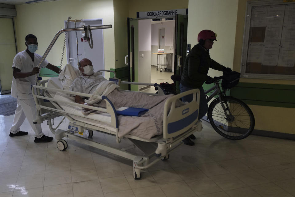 A patient is carried in a bed at the Hospital of Argenteuil, north of Paris, Friday Sept. 25, 2020. France's health agency announced Thursday evening that the country has had 52 new deaths and has detected over 16,000 new cases of coronavirus in 24 hours. (AP Photo/Francois Mori)