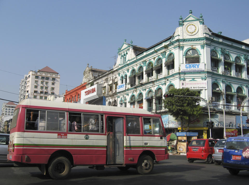 In this Wednesday, March 12, 2014 photo, a bus runs through a busy street in central Yangon, Myanmar. One of the quaintest of many anachronisms in Yangon, a city of moldering colonial villas and gleaming golden pagodas, used to be the decades old Toyotas, Chevys and other clunkers wheezing down its mostly empty roads, a visible sign of sanctions and economic isolation. Now, the streets have filled with a flood of newer used cars, mostly from Japan. (AP Photo/Elaine Kurtenbach)