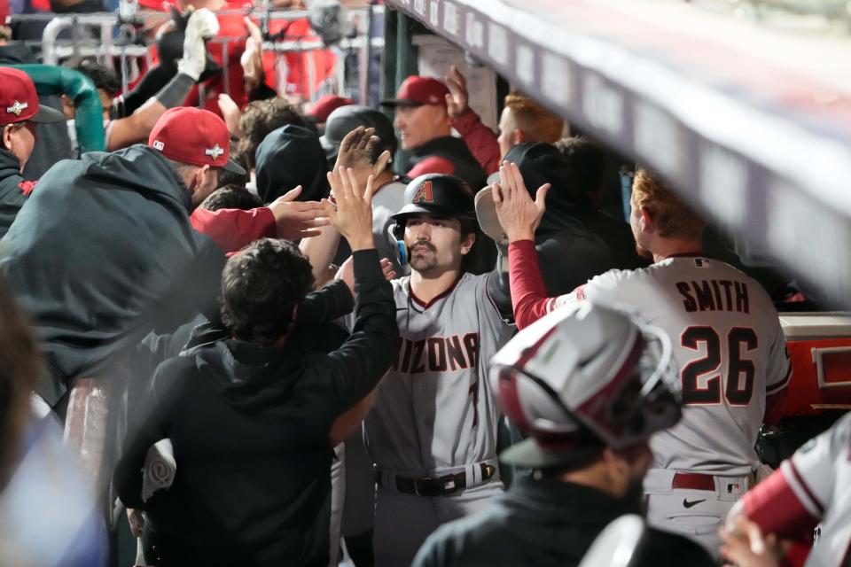 Arizona Diamondbacks left fielder Corbin Carroll (7) high fives teammates after scoring during the fifth inning against the Philadelphia Phillies in game seven of the NLCS at Citizens Bank Park in Philadelphia on Oct. 24, 2023.