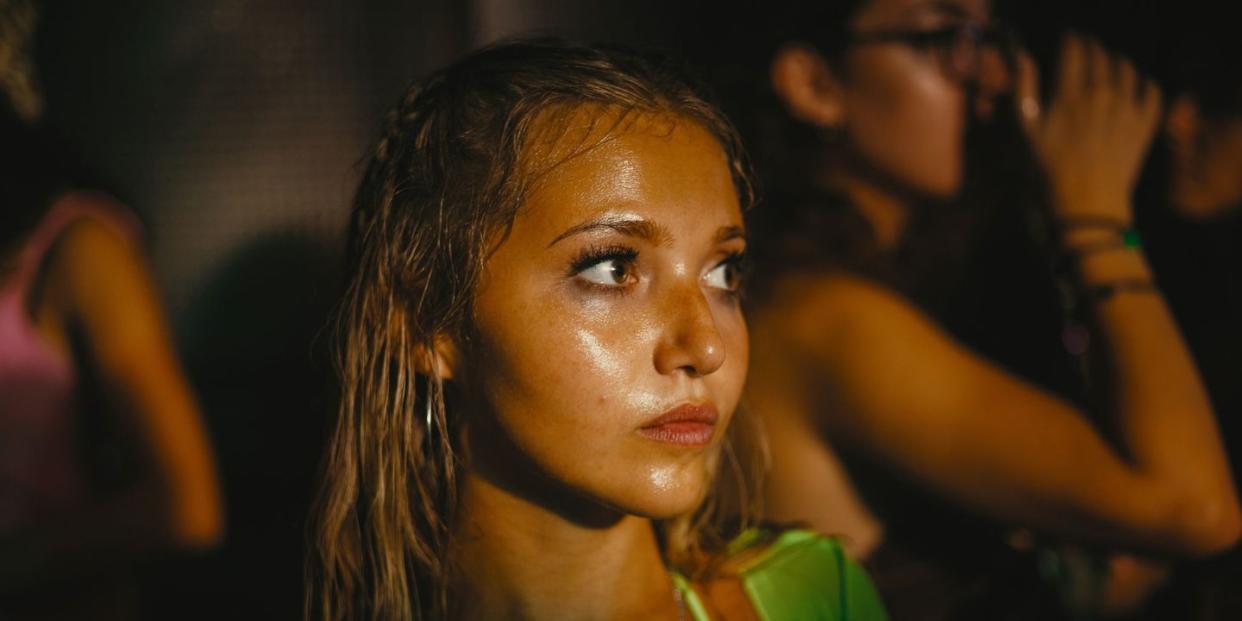 a woman with long hair and a green top in a club