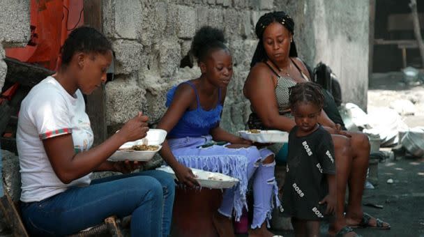 PHOTO: Cite Soleil residents eat donated lunch. (Bernabe Leobardo Salinas Jasso/ABC News)