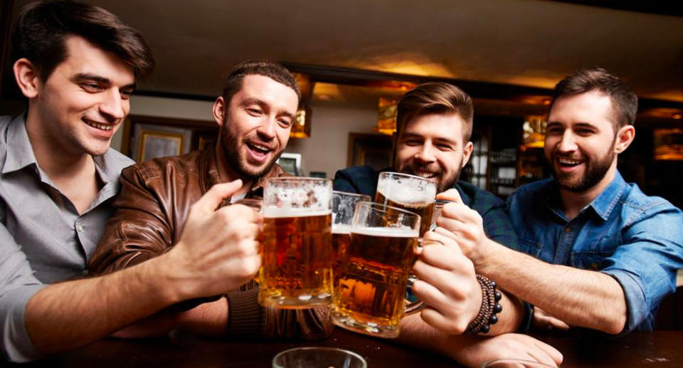 Four men cheers with pints of beer