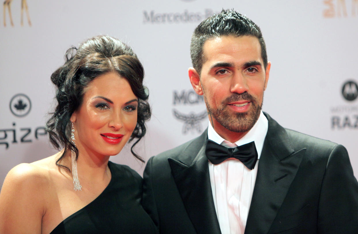 (FILES) In this file photo taken on November 10, 2011 German-Tunisian rap singer Bushido (R) poses with his partner Anna Maria Lagerblom, now called Anna-Maria Ferchichi, as they arrive for the Bambi awards ceremony in Wiesbaden, Germany. - Berlin crime gangs of Arab origin have long earned infamy with gang violence and brazen robberies but now, police warn, they have targeted a new generation of refugees for recruitment. Germany's best-known rapper, Bushido, long boasted about his close ties to one Berlin clan -- until they had a falling out this year and he sought the protection of a rival group. (Photo by DANIEL ROLAND / AFP) / Germany OUT / TO GO WITH AFP STORY BY YANNICK PASQUET AND FRANK ZELLER        (Photo credit should read DANIEL ROLAND/AFP via Getty Images)