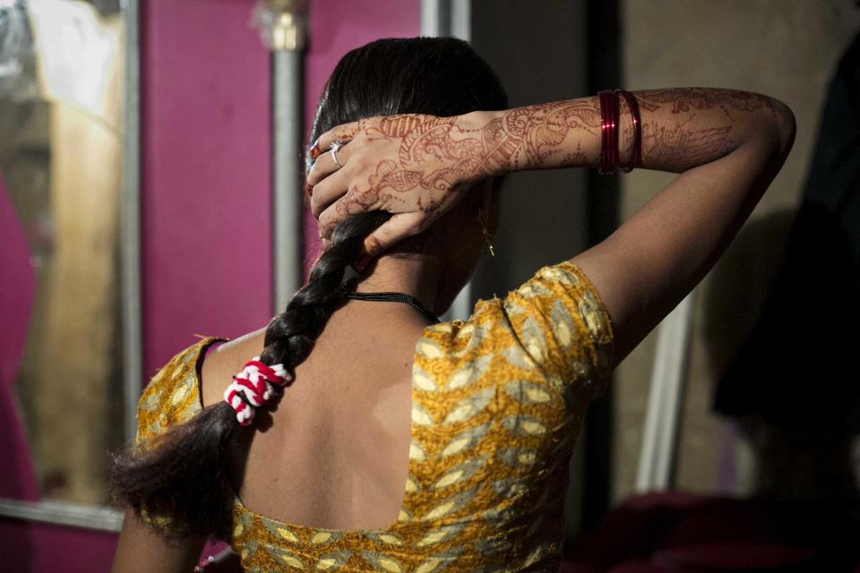 UTTAR PRADESH, INDIA - AUGUST 2: 15 year old Priyanka (name changed) fixes her hair on August 2, 2016 in Uttar Pradesh, India. She was raped by a neighbor last year when she was 14 years old. The neighbor had been harassing her for a long time and then one night he came on motorcycles with friends and threatened to kill her if she didn't get on the bike with him. He took her to a friend's house and raped her. For 10 days the police refused to register a case against him and when they did, they held her for two days in the station until she agreed to say in the statement that she went willingly with the him. Priyaka and her family say that he comes from a rich, influential family. The people in her village gossip, they say that she ran away willingly with him and that she did bad things. After the rape he continues to harass her, sending his friends to tell her that if he sees her he will kill her, that he will come and kidnap her sisters, that he will kill her father. Recently the rapist and his friends saw her father on the road and they beat up him. Two weeks ago Priyanka was wed to a 22 year old man in a marriage that her family arranged for her. They were worried about her safety and Priyanka thought that she would be safer if she was married and living in a different village. Her husband doesn't know about the rape, and the rapist has sent letters to her home threatening to tell her new family and break up the marriage. 'I feel angry. There's nothing left in me.' Priyanka says. (Photo by Getty Images)