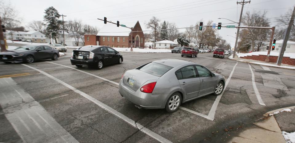 Cars pass through the Grand Avenue and 13th Street intersection on Thursday. The city could acquire the Seventh Day Adventist Church at 1303 Grand Ave. to widen the the streets and add turn lanes.