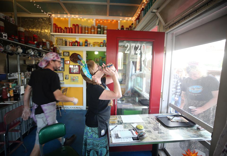 Heidi Yoxsimer plays Happy Birthday on the kazoo to Stephanie McCrary at the order window of Hi-Lo's 15th Street Cafe in Bremerton on Saturday.