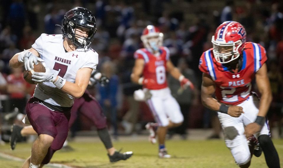 Navarre's Nate Hanson (No. 7) finds running room as Pace's Brayden Gates (No.23) prepares for the hit during Friday night's District 1-4S game between the Patriots and the Raiders.
