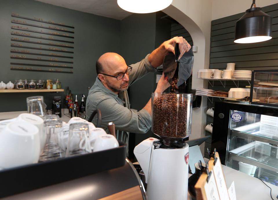 Fran Basile fills a machine with fresh beans at Hydra coffee.