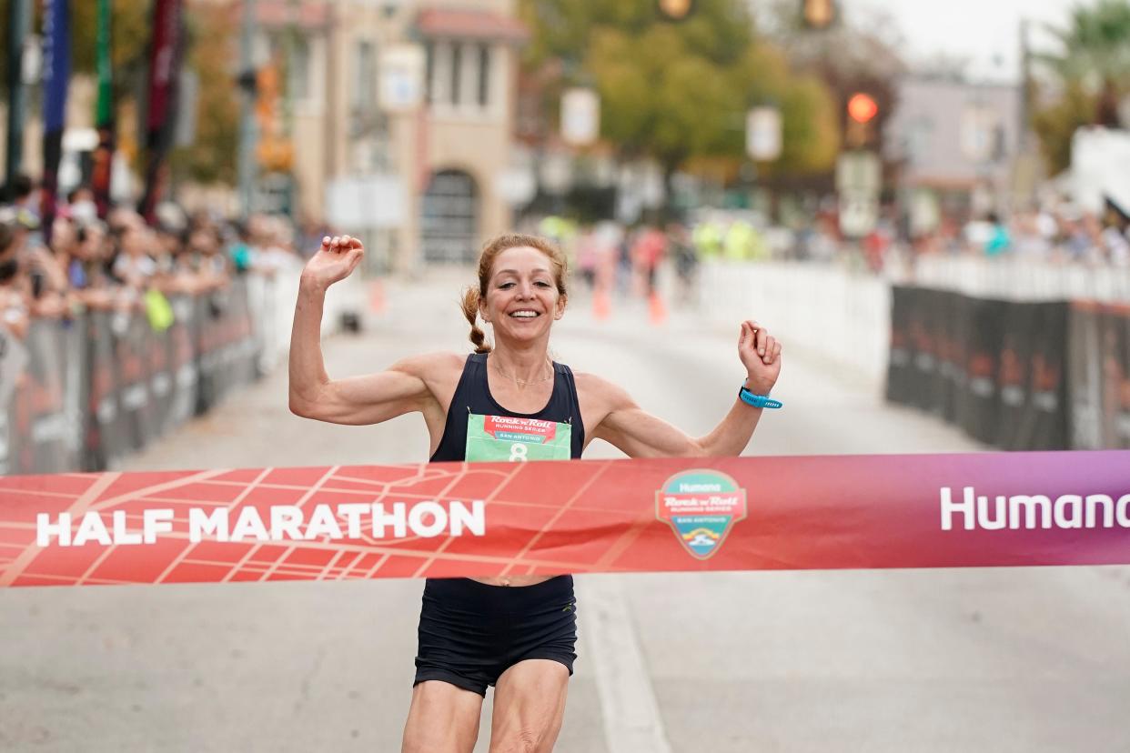 SAN ANTONIO, TEXAS - DECEMBER 05: Andrea Pomaranski celebrates as she crosses the finish line to win the women's half marathon at Rock 'n' Roll Running Series San Antonio on December 05, 2021 in San Antonio, Texas.