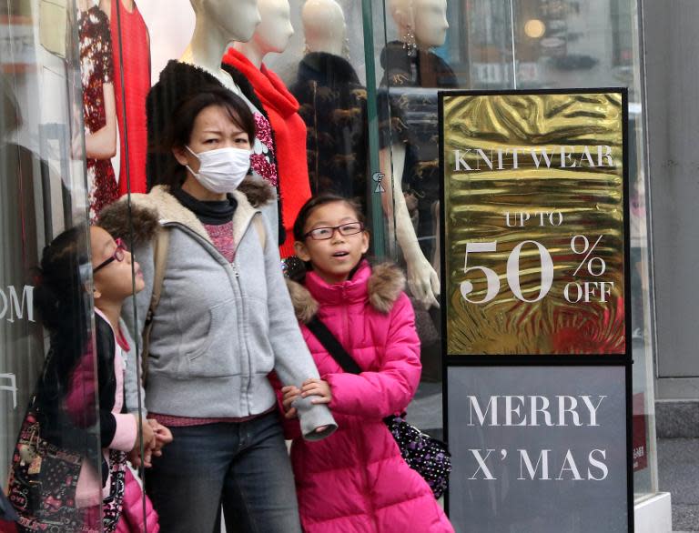 Customers walk out from an apparel shop in Tokyo, on November 17, 2014