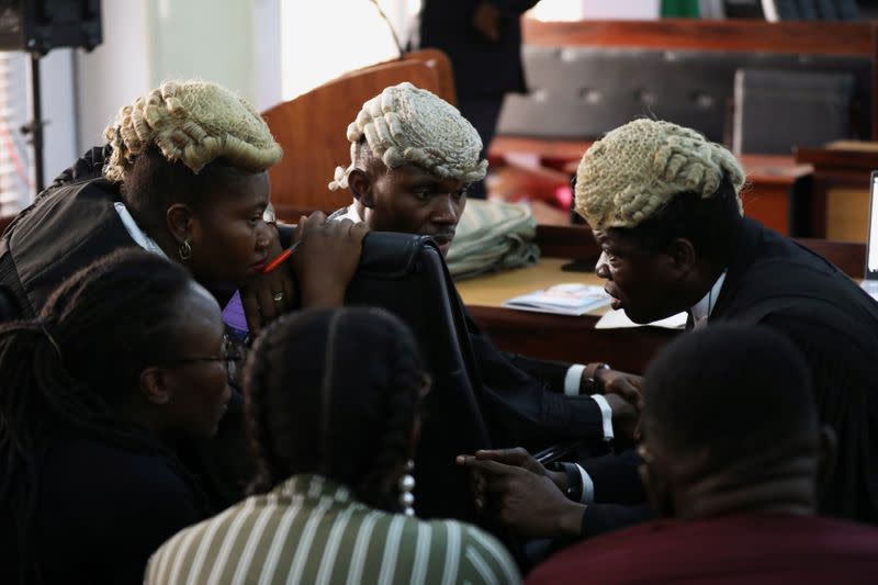 The defense legal team for the men charged with public display of affection with members of the same sex discuss during the trial at the Federal High Court in Lagos