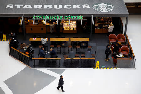 FILE PHOTO: People sit in a Starbucks cafe in a mall in Beijing, China, January 29, 2019. REUTERS/Thomas Peter