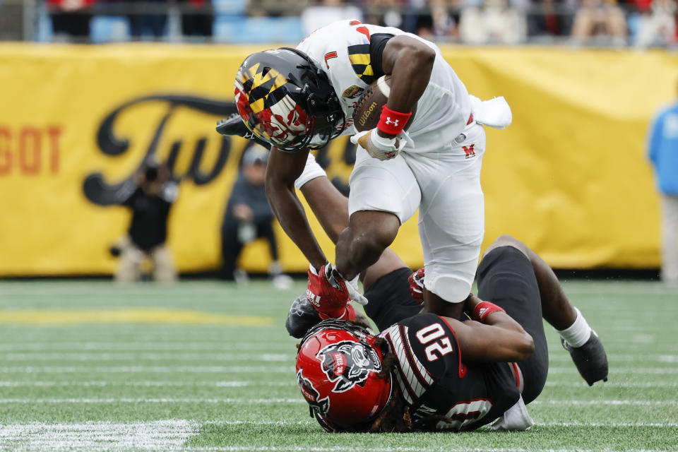 Maryland wide receiver Dontay Demus Jr. fights for yardage as North Carolina State safety Sean Brown attempts to make a tackle during the first half of the Duke's Mayo Bowl NCAA college football game in Charlotte, N.C., Friday, Dec. 30, 2022. (AP Photo/Nell Redmond)