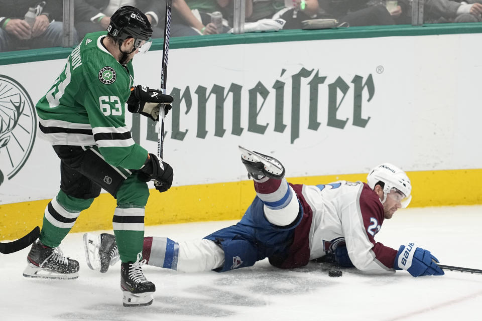 Dallas Stars right wing Evgenii Dadonov (63) knocks Colorado Avalanche's Sean Walker (26) to the ice as they competed for the puck during the third period in Game 2 of an NHL hockey Stanley Cup second-round playoff series in Dallas, Thursday, May 9, 2024. (AP Photo/Tony Gutierrez)