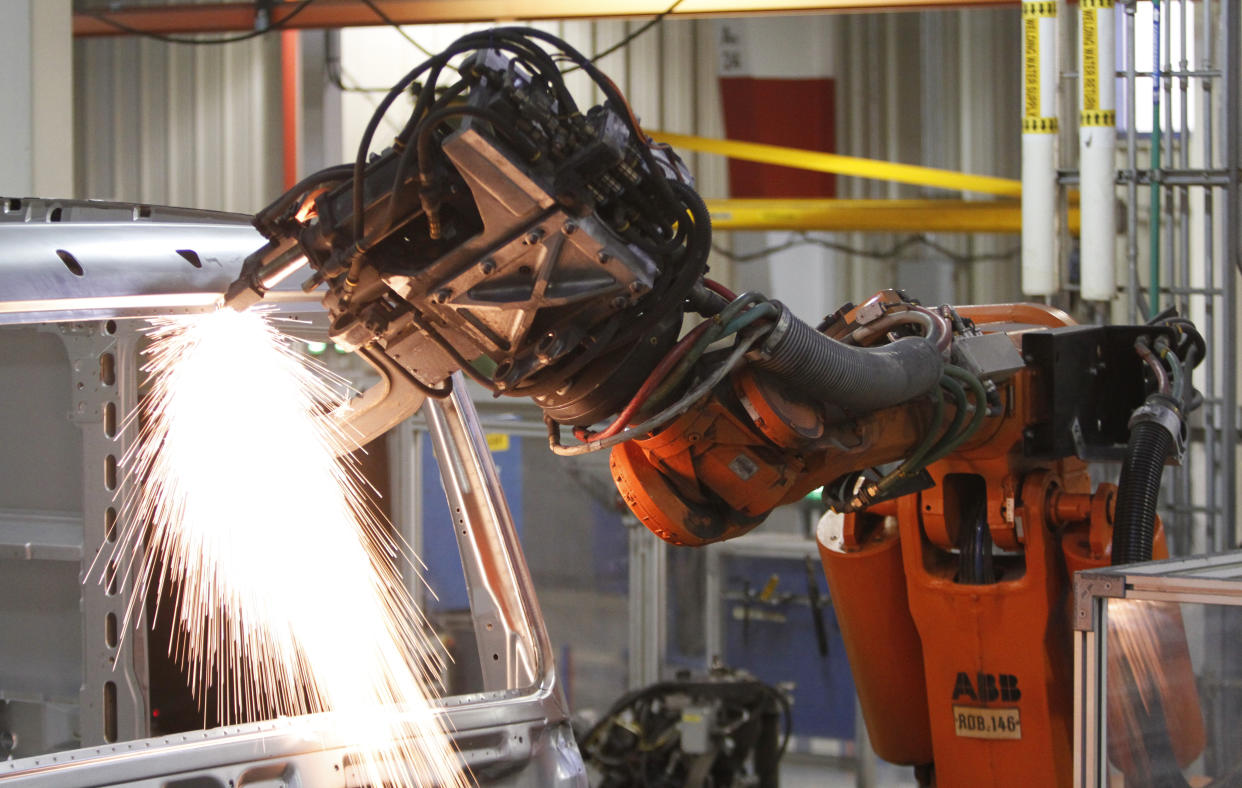 An industrial robot welds a car together. Source: AP