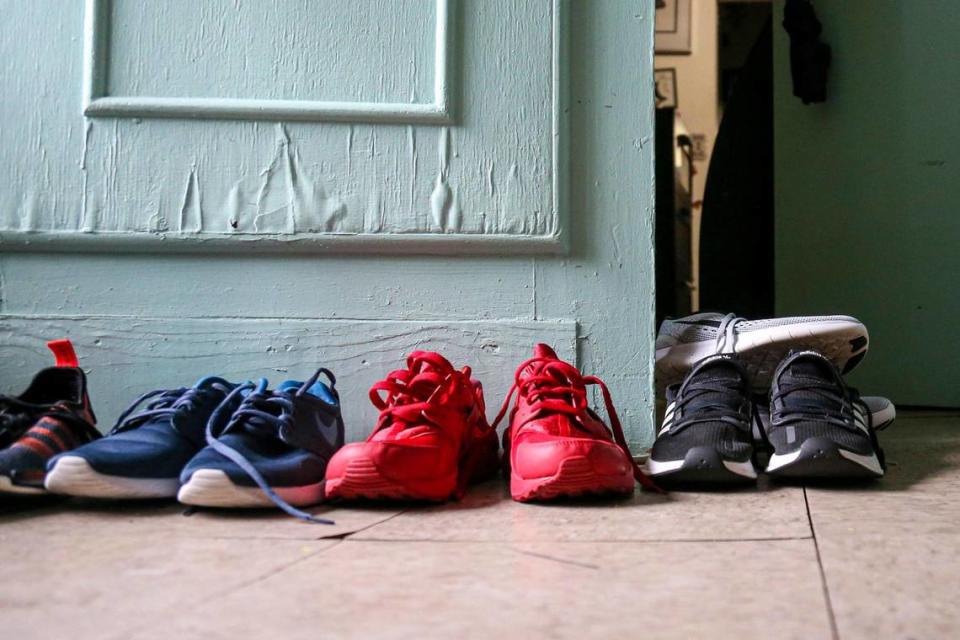 Pares de zapatos de la familia Murillo se secan junto a una puerta dañada por la absorción de agua después de que su casa de alquiler se inundara debido a un fin de semana de fuertes lluvias en el barrio de La Pequeña Habana en Miami, Florida, el viernes 10 de junio de 2022.