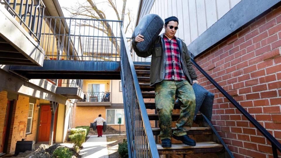 After being told to move out as soon as possible, siblings Margarita Gomez, background, and Michael Gomez, foreground, begin to take furniture and other belongings out to a moving trailer at Cambridge Apartments in Boise, on March 16. All Cambridge residents received notice to move out as soon as possible because of unreliable heating in the housing complex.