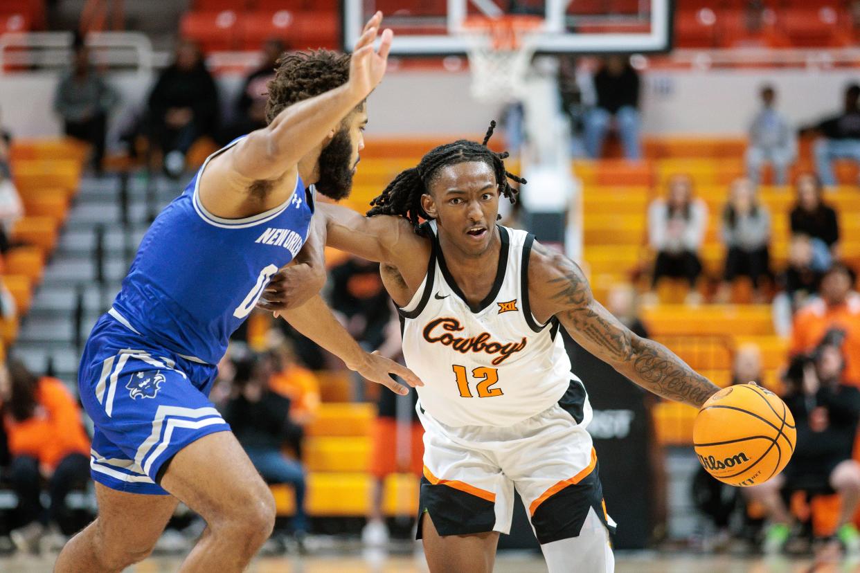 Nov 20, 2023; Stillwater, Oklahoma, USA; Oklahoma State Cowboys guard Javon Small (12) drives past New Orleans Privateers guard Mason Jones (0) during the first half at Gallagher-Iba Arena. Mandatory Credit: William Purnell-USA TODAY Sports