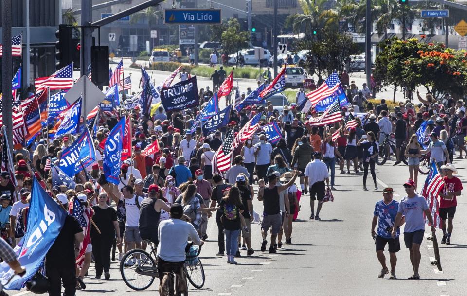 Trump supporters wave flags and signs while hoping to get a glimpse of the president's motorcade.