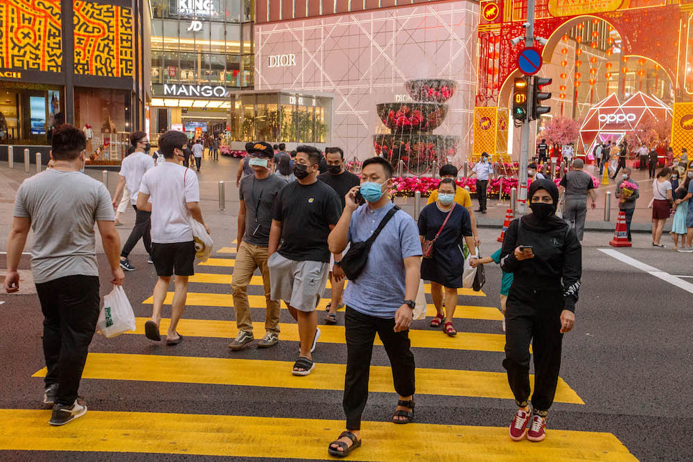 People wearing facemasks cross the road in front of Pavilion in Bukit Bintang amid the movement control order in Kuala Lumpur February 16, 2021. — Picture by FIrdaus Latif