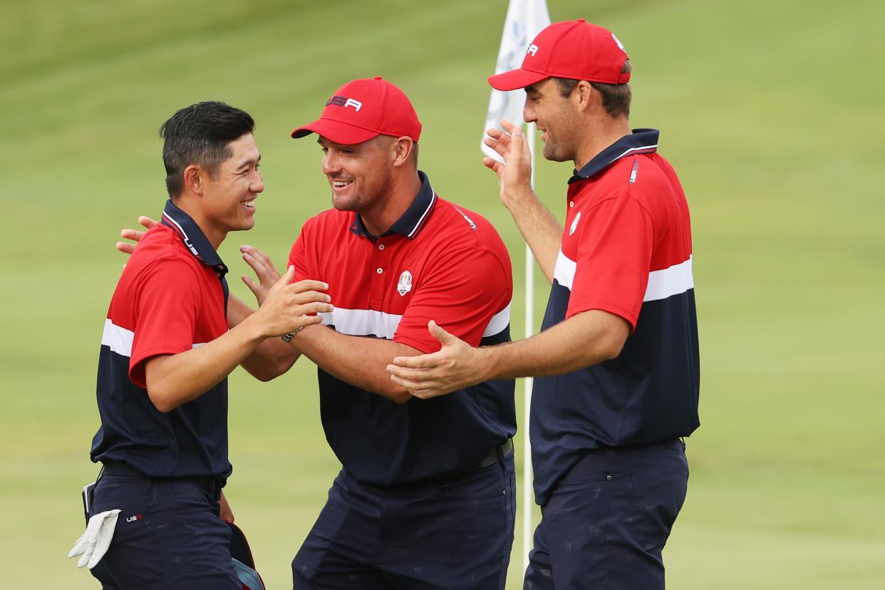 KOHLER, WISCONSIN - SEPTEMBER 26: Collin Morikawa of team United States celebrates on the 18th green with Bryson DeChambeau of team United States and Scottie Scheffler of team United States after winning the half point needed to win during Sunday Singles Matches of the 43rd Ryder Cup at Whistling Straits on September 26, 2021 in Kohler, Wisconsin. (Photo by Patrick Smith/Getty Images)