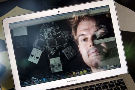 German crypto specialist and and chief scientist with Berlin's SR Labs Karsten Nohl is reflected in a computer screen as he looks at photographs of USB sticks in his office in Berlin, July 30, 2014. REUTERS/Thomas Peter