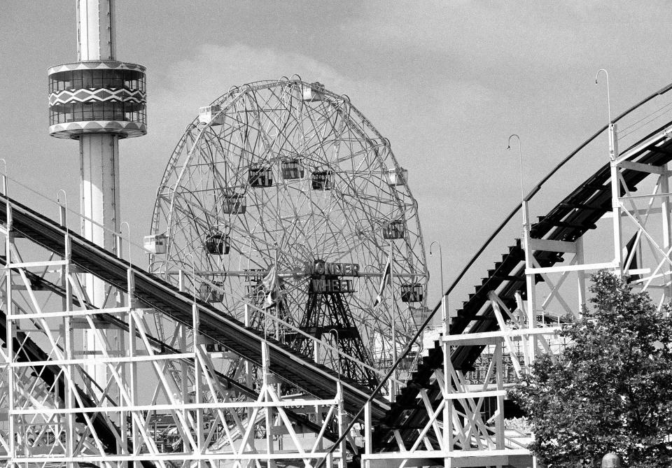 FILE- In this June 30, 1977 file photo, the 275-foot tall Astrotower , left, reaches into the sky along with the 150-foot-tall Wonder Wheel, and the Cyclone roller coaster snakes through the foreground at the Astorland amusement park in the Coney Island section of the Brooklyn borough of New York. The iconic Coney Island amusement park was evacuated, Tuesday, July 2, 2013 after reports that the Astrotower observation tower was swaying in the wind. (AP Photo, File)