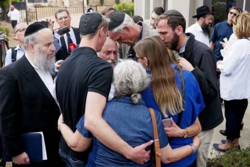The Chabad of Poway congregation console one another after a teenage gunman stormed their synagogue on the last day of Passover, killing one and wounding three