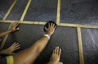 Muslim pilgrims touch the Kaaba at the Grand Mosque in the holy city of Mecca ahead of the annual Haj pilgrimage October 7, 2013. REUTERS/Ibraheem Abu Mustafa (SAUDI ARABIA - Tags: RELIGION)