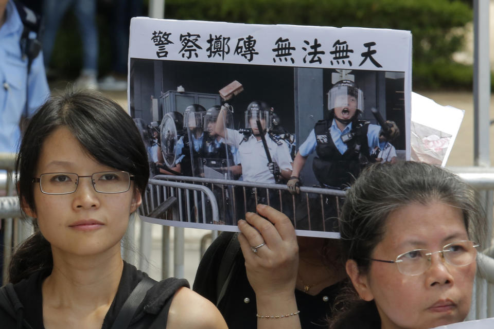 Various of activist groups from parents and religious hold placards featuring a police throwing a brick with Chinese reading "Police throwing brick is lawlessness" outside the government office demanding that stop shooting their kids in Hong Kong, Thursday, June 20, 2019. A Hong Kong student group demanded Wednesday that the city completely scrap a politically charged extradition bill and agree to investigate police tactics against protesters before a Thursday deadline or face further street demonstrations. (AP Photo/Kin Cheung)