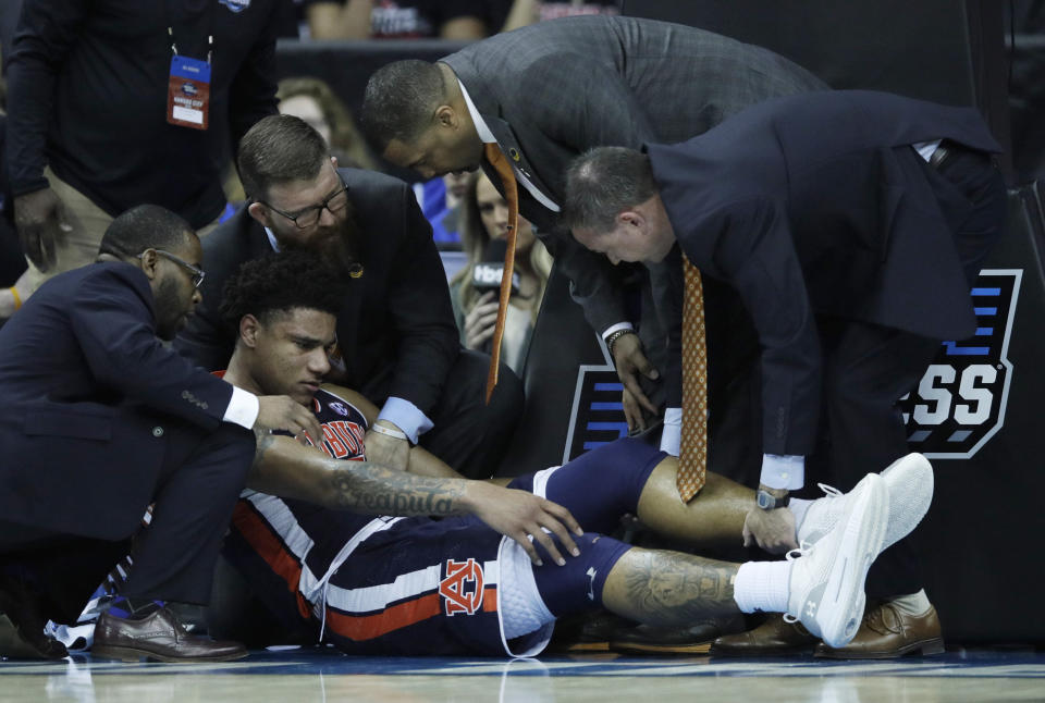 Trainers assist Auburn's Chuma Okeke after he was injured during the second half of a men's NCAA tournament college basketball Midwest Regional semifinal game against North Carolina Friday, March 29, 2019, in Kansas City, Mo. (AP Photo/Orlin Wagner)