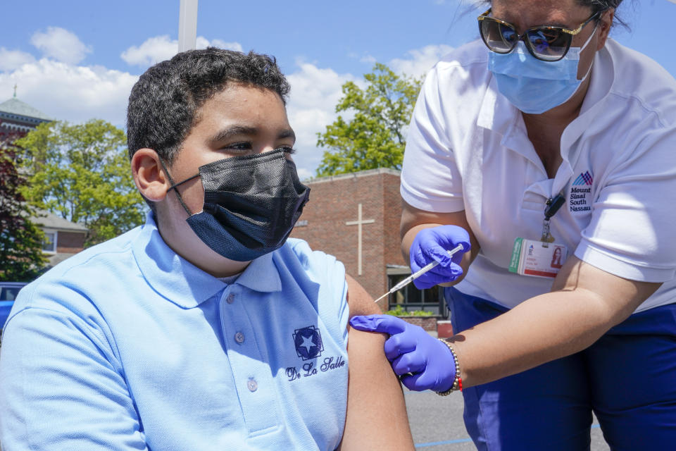Nurse Practitioner Amber Vitale inoculates Stanley Pena, 13, with the first dose of the Pfizer COVID-19 vaccine at the Mount Sinai South Nassau Vaxmobile parked at the De La Salle School, Friday, May 14, 2021, in Freeport, N.Y. The De La Salle School partnered with the Vaxmobile Friday to help Long Island students 12 and over receive the first dose of the Pfizer COVID-19 vaccine as part of Mount Sinai South Nassau's mobile vaccination program. (AP Photo/Mary Altaffer)