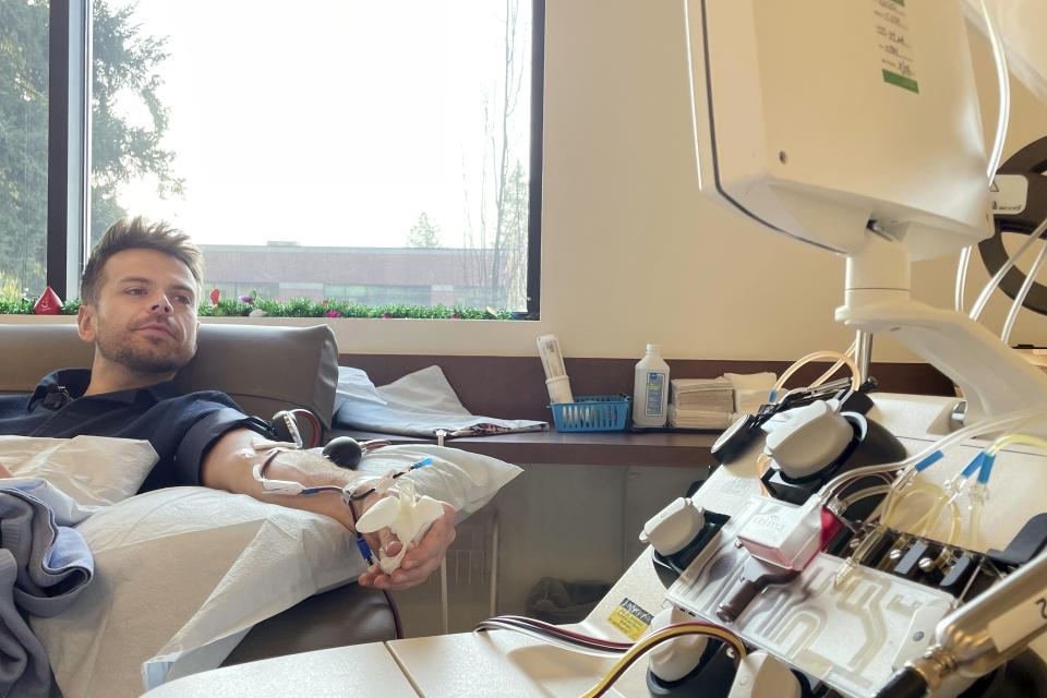 Dylan Smith donates blood platelets at Bloodworks Northwest, where he works as a donor services supervisor, Friday, Dec. 15, 2023, in Vancouver, Wash. More gay and bisexual men can now donate blood in the U.S., and many in Washington state are doing so. (AP Photo/Claire Rush)