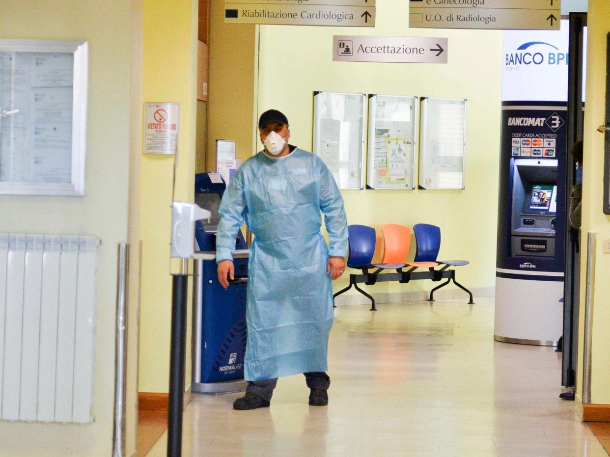 A health worker wearing a face mask walks in a corridor of the Codogno Civic Hospital in Lodi, northern Italy: EPA