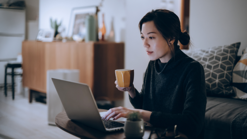 A young professional works on their laptop in their home.