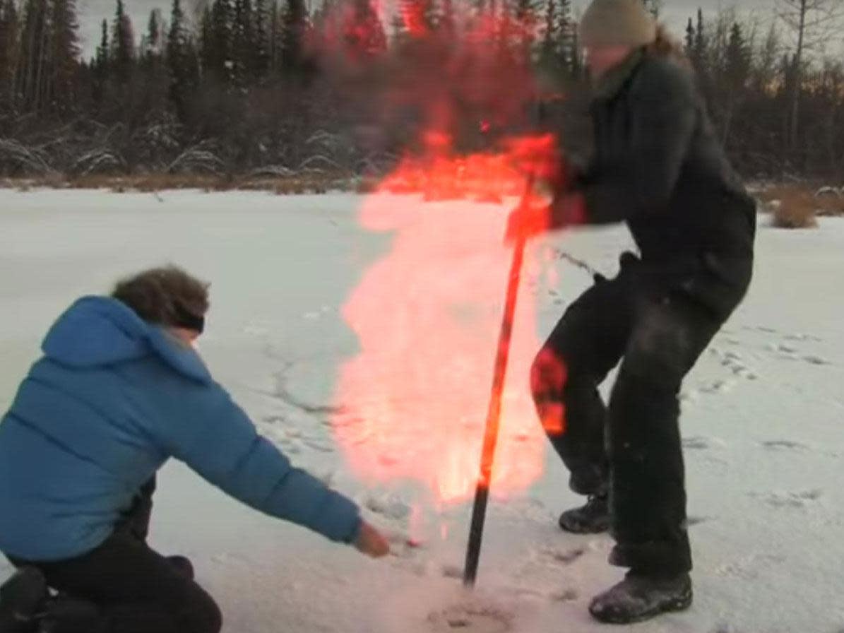 Professor Katey Walker Anthony, of Alaska University, sets fire to methane released by hitting the frozen ground with a stick: University of Alaska Fairbanks