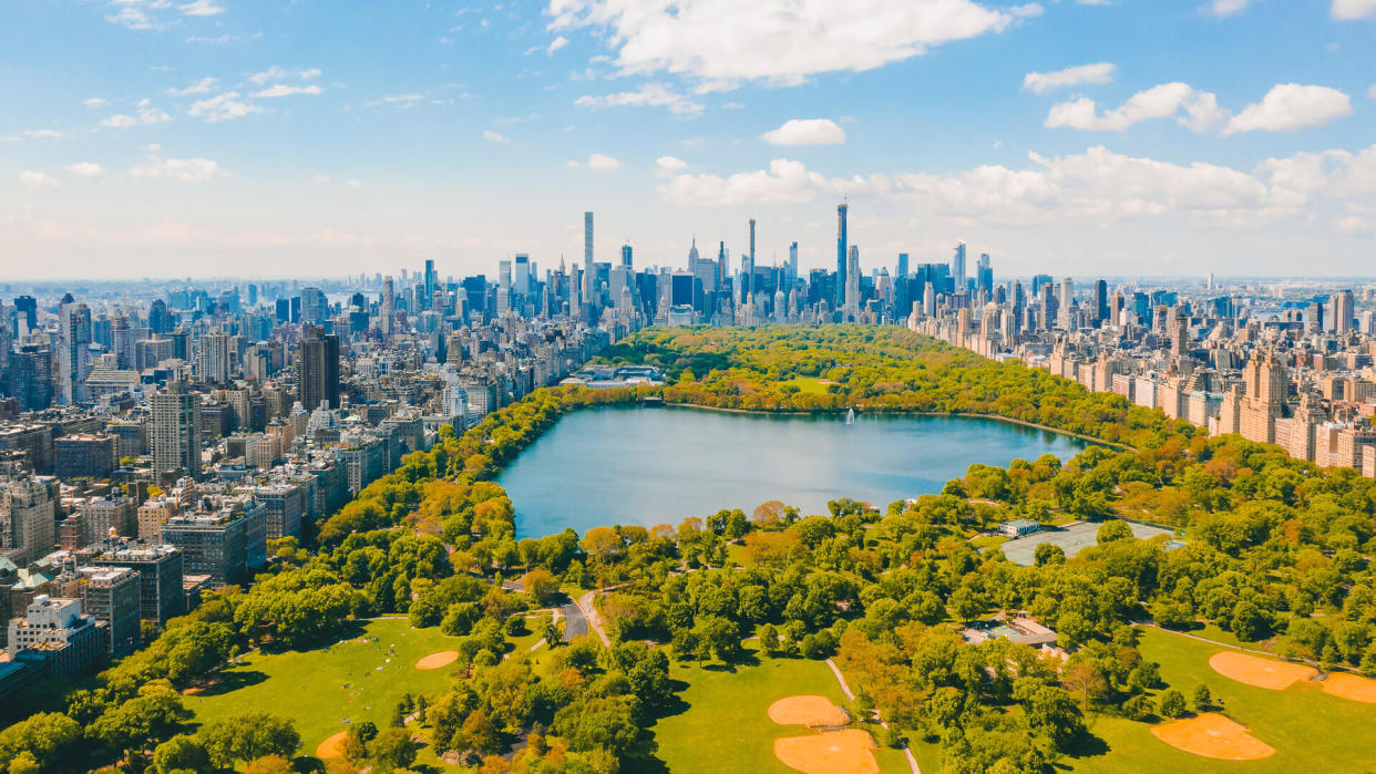 Aerial view of the Central park in New York with golf fields and tall skyscrapers surrounding the park.