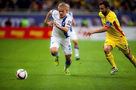 Finland's Joel Pohjanpalo is challenged by Romania's Razvan Rat (R) during their Euro 2016 Group F qualification soccer match in Bucharest, Romania October 8, 2015. REUTERS/Inquam Photos/Ovidiu Micsik