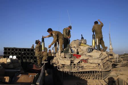 Israeli soldiers load shells on to a tank near the border of southern Gaza Strip August 1, 2014. REUTERS/Baz Ratner