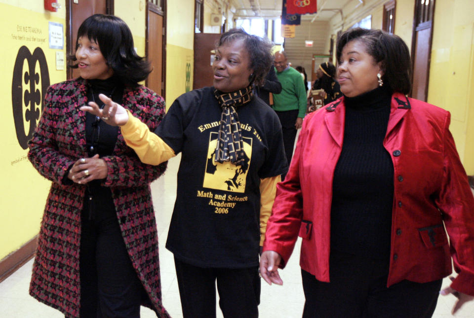 FILE - In this Feb 24, 2006, file photo, Deborah Watts, left, and Ollie Gordon, right, both cousins of Emmett Till, accompany Principal Mary Rogers as they walk through a hallway at Emmett Louis Till Math & Science Academy, in Chicago, honoring the 14-year-old former student. Till's lynching galvanized the civil rights movement. George Floyd, the Black Minneapolis man's killing by police sparked a worldwide call for racial justice. The deaths of Till and Floyd are separated by more than six decades, but their families feel a deep connection in their grief. (AP Photo/M. Spencer Green, File)