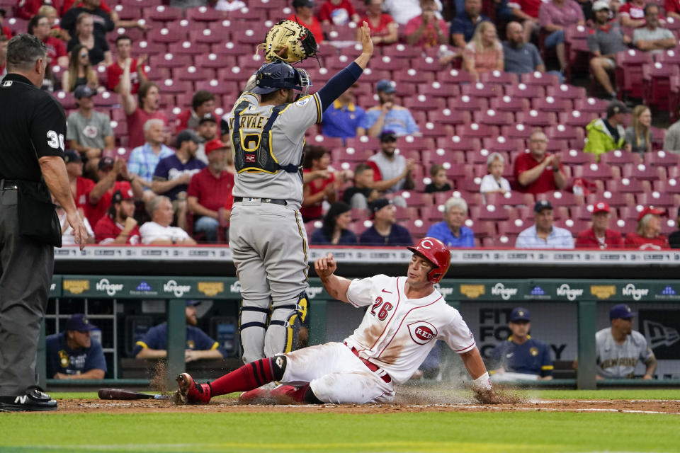 Cincinnati Reds' Scott Heineman scores on a single by Jonathan India during the second inning of the team's baseball game against the Milwaukee Brewers in Cincinnati on Wednesday, June 9, 2021. (AP Photo/Jeff Dean)